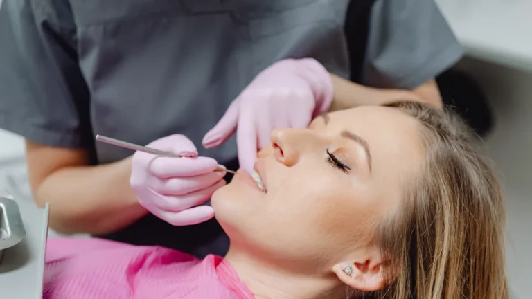 Dentista examinando os dentes de uma paciente deitada na cadeira odontológica